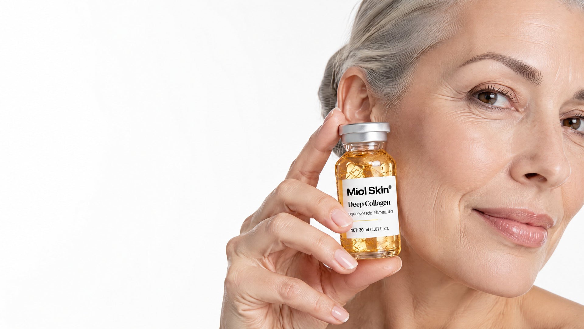 Une femme tient le sérum Miol Skin contre sa joue